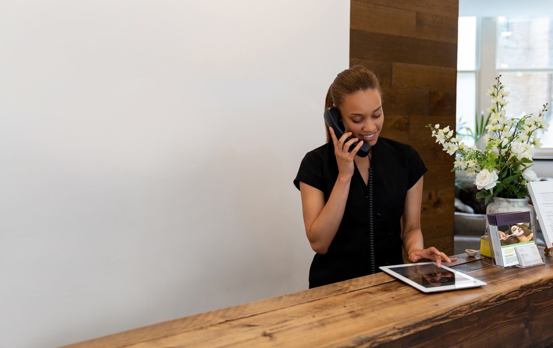 Masseuse on the phone booking an appointment at the spa